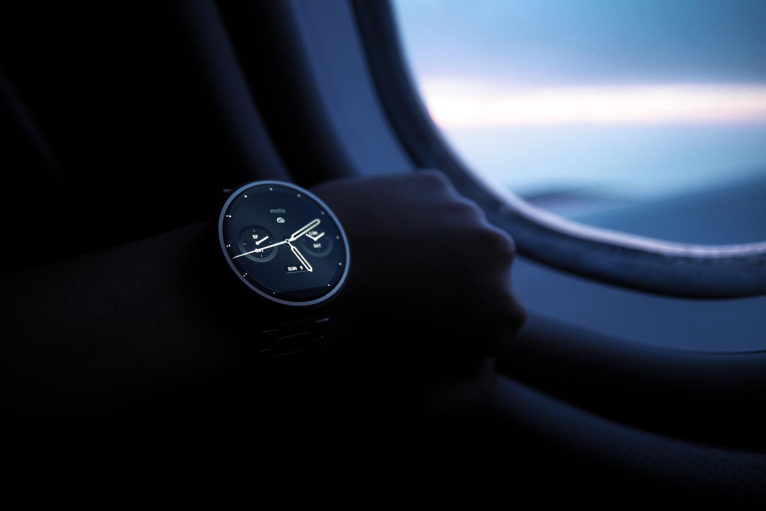 Montre et hublot d’avion au crépuscule